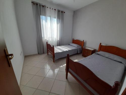 a bedroom with two beds and a window at Elezi House in Durrës
