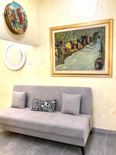a couch in a room with a painting on the wall at Eruption1669 in Catania