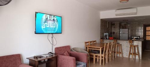 a living room with a tv hanging on the wall at شالية بقرية بالميرا in Ain Sokhna
