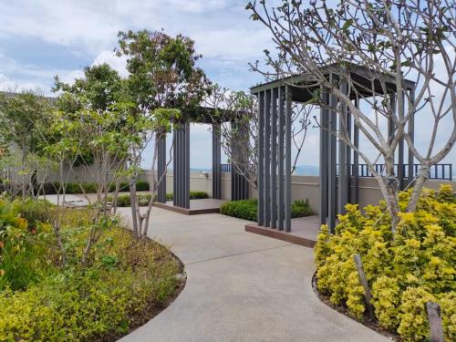 una pasarela a través de un jardín con árboles y arbustos en Youth City Nilai, en Nilai
