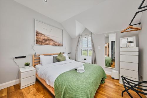 ein Schlafzimmer mit einem Bett mit einer grünen Decke in der Unterkunft Dunluce Park 5 - Portrush by the Sea in Portrush