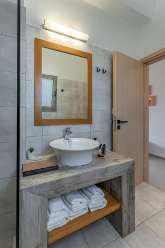 a bathroom with a sink and a mirror and towels at Yiasemi in Skiros