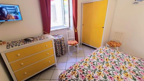 a small room with two beds and a dresser and a dresser at Appartamenti Tina in Villa Restituta in Ischia