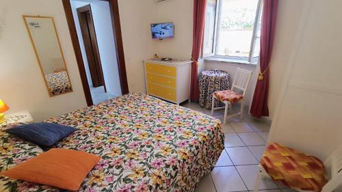 a bedroom with a bed and a dresser and a window at Appartamenti Tina in Villa Restituta in Ischia