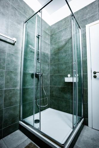 a shower with a glass door in a bathroom at Chambre R1 avec salle de bain privée in Liège