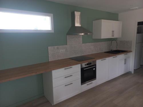 une cuisine avec des armoires blanches et un comptoir dans l'établissement La maison du menhir, à Crozon