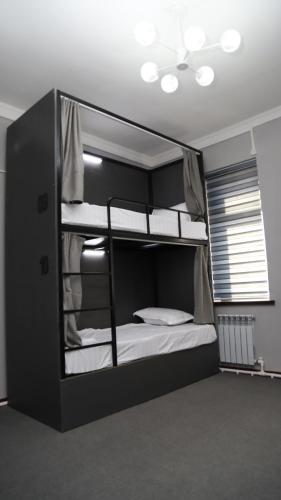 a bedroom with a bunk bed with white sheets at Nazar Hotel & hostel in Türkistan