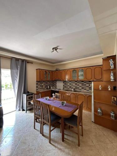una cucina con tavolo e sedie in una stanza di Dajanas apartment a Këlcyrë