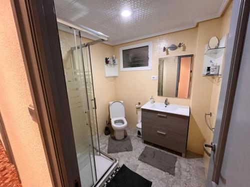 Un baño con inodoro, lavabo y ducha. en Manda Pola, en Santa Pola