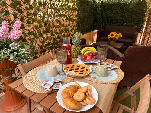 a table with plates of bread and fruit on it at Residenza MIMOSA - in centro - in Sassari