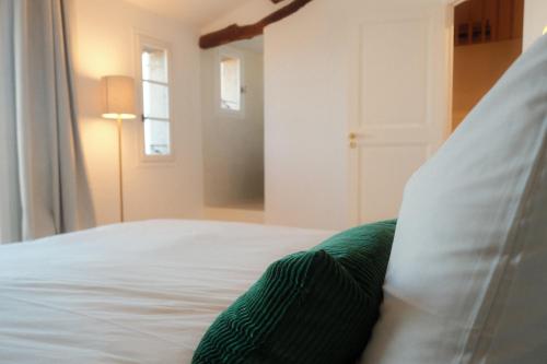 a white bed with a pillow and a window at Appartement Duplex Le Mimosa Parking a proximité vue exceptionnelle in Grasse