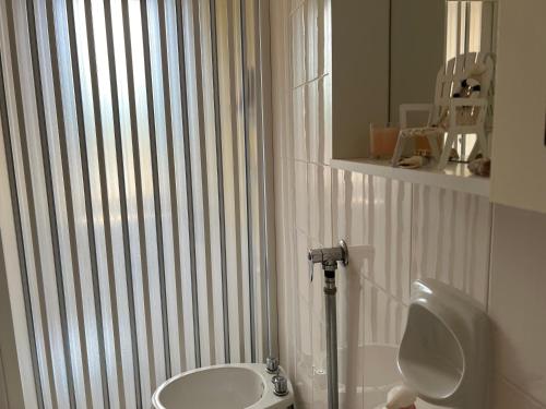 a bathroom with a toilet and a sink and a mirror at Nonna Ciccina’s House in Vita