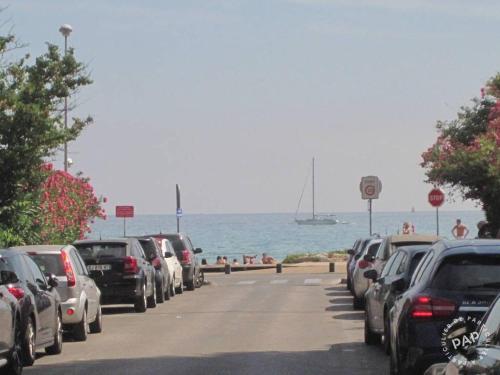 Une rangée de voitures garées dans une rue à côté de l'océan dans l'établissement Studio a 50 metres de la plage, à La Ciotat