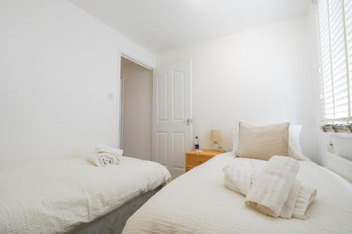 リビングストンにあるLivingston 4 Bed + Car Spaceの白いベッドルーム(ベッド2台、窓付)