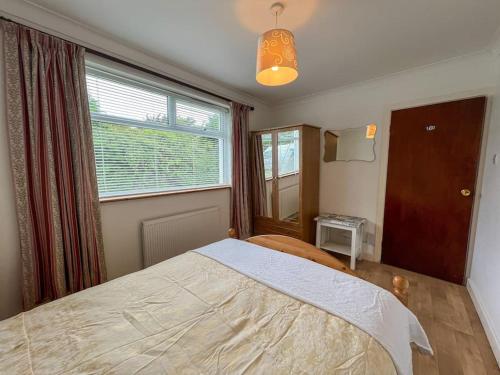 a bedroom with a bed and a large window at Mountain View at Grange Beg # 2 in Doonflin Lower
