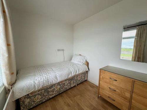 a small bedroom with a bed and a dresser at Mountain View at Grange Beg # 2 in Doonflin Lower