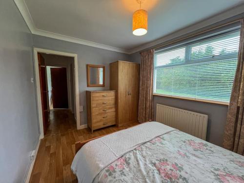 a bedroom with a bed and a window and a dresser at Mountain View at Grange Beg # 2 in Doonflin Lower