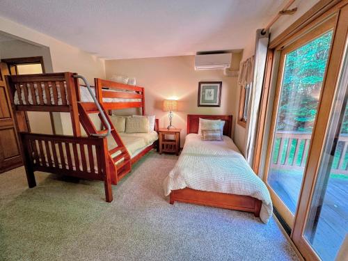 a bedroom with a bunk bed and a twin bed at O8 Renovated Forest Cottage Townhome with great Mt Washington views fast wifi Walk to skiing in Carroll