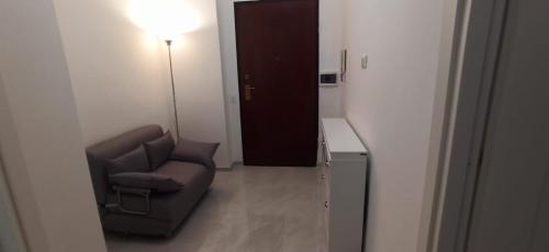 a room with a chair and a lamp and a door at Rome's Beach Sweet Home in Torvaianica