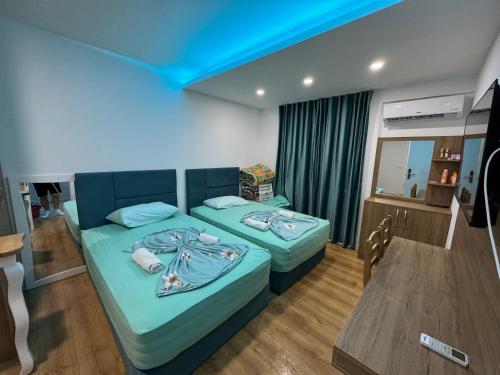 a bedroom with two beds and a blue ceiling at Suite Rana Hedhun in Shëngjin