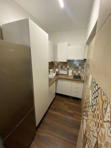 a kitchen with white cabinets and a stainless steel refrigerator at RS AL Cruz Quebrada in Cruz Quebrada
