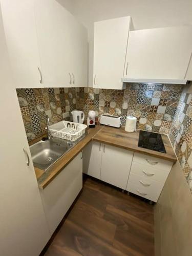a small kitchen with white cabinets and a sink at RS AL Cruz Quebrada in Cruz Quebrada