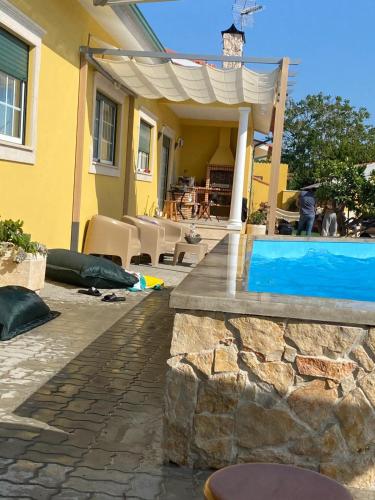 a yellow house with a swimming pool in a yard at Casa da Ereira in Montemor-o-Velho