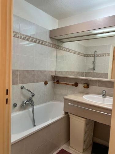 une salle de bain avec une baignoire et un lavabo dans l'établissement Appartement cosy piscine plage 2 pièces, à Fréjus
