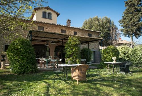 eine Außenterrasse mit Tischen und Stühlen im Hof in der Unterkunft Il Borghetto Country Inn in San Casciano in Val di Pesa