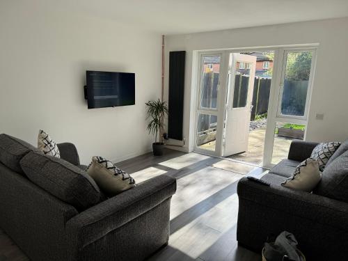 a living room with two couches and a tv at Do not book having difficulty removing from page house is not bookable in Derby