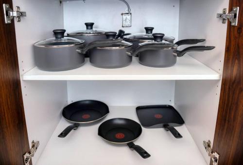 three pots and pans on a stove in a kitchen at Empire State View - Luxury Apt - Shuttle to NYC in Hoboken