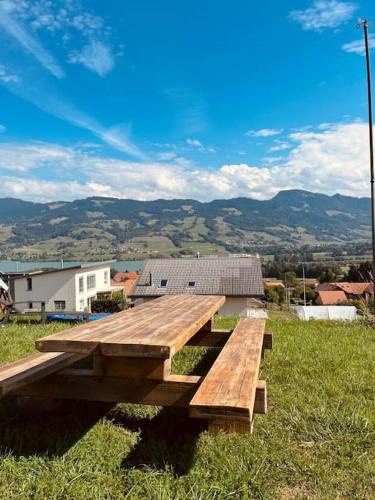 a wooden picnic table sitting on top of a field at Ferme Pasquier - Farmhouse with panoramic view - 1000 m2 garden in Avry devant Pont