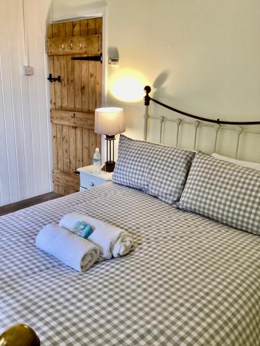 een bed met twee handdoeken erop bij Tythe Barn Cottage in Glastonbury