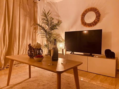 a living room with a table with two glasses of wine at Cosy Maracuja, appartement calme à 2 min de la plage ! in Orient Bay