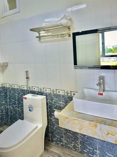a bathroom with a toilet and a sink at Khách sạn Sinh Hiền in Liên Trì (4)