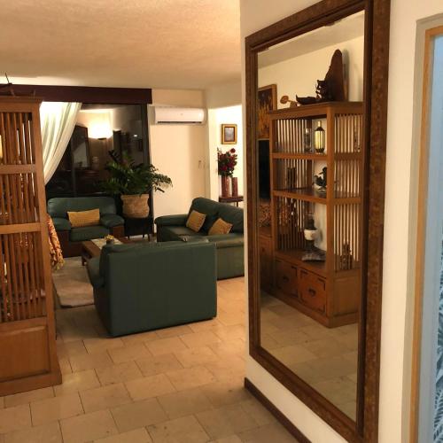 a living room with a mirror and a couch at Poerava Tahiti in Papeete