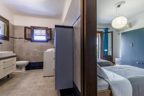 a bathroom with a bed and a toilet and a sink at Alexandra Pool Villa - Comfort & Views Near Town in Skopelos Town
