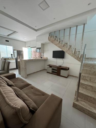 a living room with a couch and a staircase at Duplex - Villa dos Diamantes in Porto Seguro