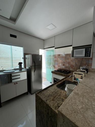 a kitchen with stainless steel appliances and a counter top at Duplex - Villa dos Diamantes in Porto Seguro
