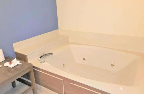 a white bath tub in a bathroom with a table at Best Western Fishers Indianapolis Area in Fishers