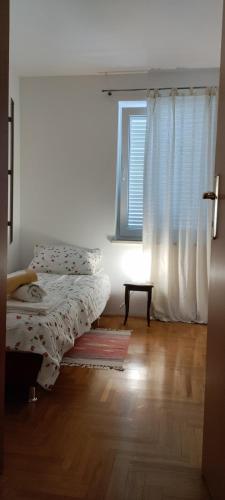 a bedroom with a bed and a window at Apartman KalaMar in Crikvenica