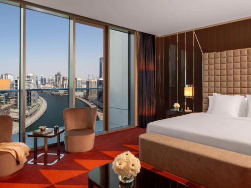 a hotel room with a bed and a large window at Hyde Hotel Dubai in Dubai