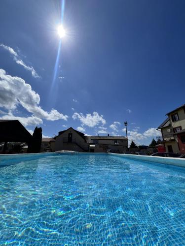 a large swimming pool with the sun in the sky at Bajkowe Zacisze - Basen, Ping-pong, Bilard in Mielno