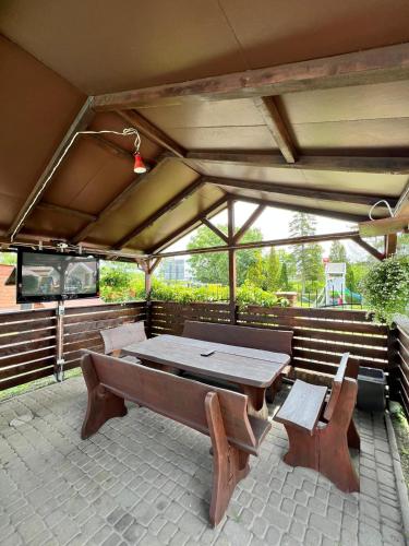 a picnic table and benches on a patio at Bajkowe Zacisze - Basen, Ping-pong, Bilard in Mielno