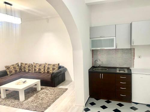 una sala de estar con un sofá y una mesa en Centrum Apartman & Rooms, en Ulcinj