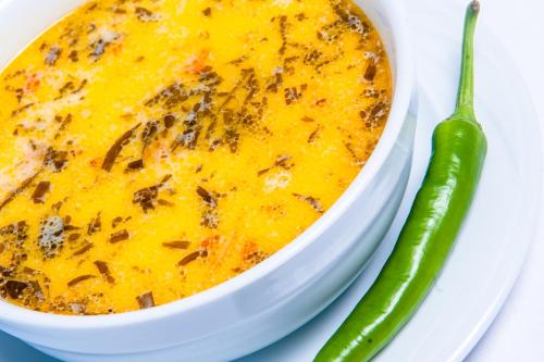 a bowl of chili cheese dip next to a pickle at Hotel Parc Sibiu in Sibiu