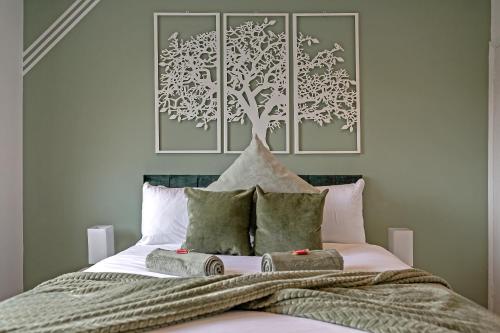 a bedroom with a bed with a tree above it at Supreme Luxury Apartment-Close to Airport-Free Parking in Luton