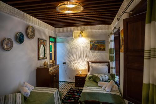 a bedroom with two twin beds in a room at Riad Taj Fes in Fès