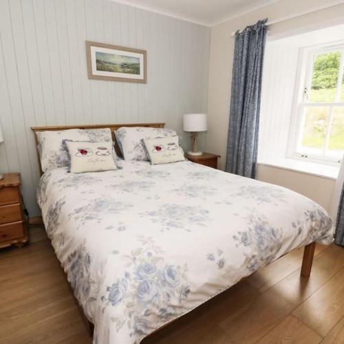 a bedroom with a bed with pillows on it at Cnocachanach Cottage in Tarbert