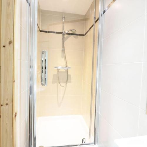 a shower with a glass door in a bathroom at Cnocachanach Cottage in Tarbert